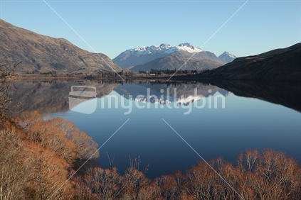The Remarkables and surrounds reflected in Lake Hayes on a clear winter's day,  Queenstown, New Zealand