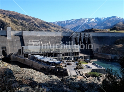 Early morning view of Clyde dam and power station on the Clutha River. Dunstan Mountains and Leaning Rock Peak beyond. New Zealand.