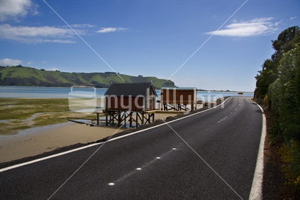 Otago Peninsula road, including boatsheds and low tide mudflats. 