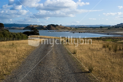 Gravel road leading down to a bay