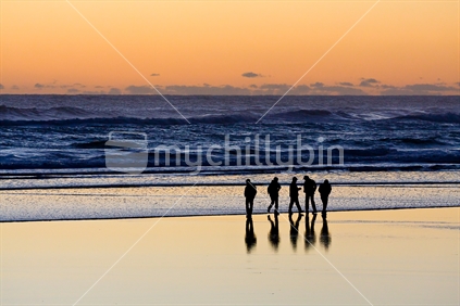Some silhouetted mates enjoying the magic hour at Muriwai beach, Auckland, New Zealand. 