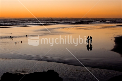 The magic hour, the beach, a couple in love, and some birds. Muriwai Beach, New Zealand