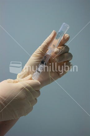 Doctor drawing up medicine from an ampoule with a syringe