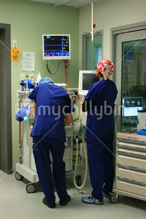 Doctors observing medical data on screens during an anaesthetic