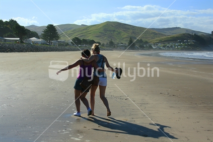 Friends walking on the beach, Castlepoint, New Zealand
