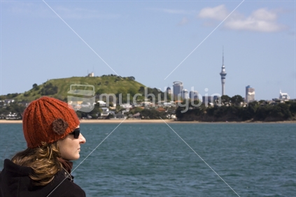 A woman overlooking North Head/Auckland Skyline from Hauraki Gulf