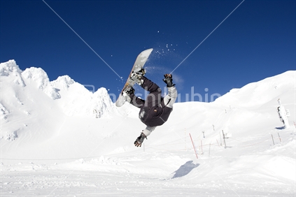 A snowboarder getting air over a jump at Whakapapa skifield. About to crash land, wipe out. Mt Ruapehu, North Island, New Zealand
