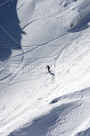 A skier riding down the slopes at Whakapapa skifield, Mt Ruapehu, North Island, New Zealand
