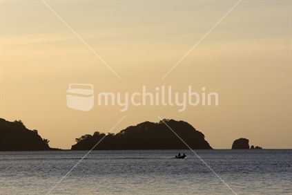A fishing boat and islands at sunset, Coromandel, North Island, New Zealand
