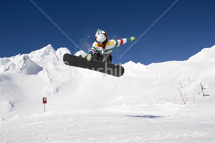 A snowboarder getting air over a jump at Whakapapa skifield. Mt Ruapehu, North Island, New Zealand