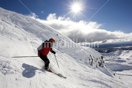 A skier riding down the slopes at Whakapapa ski field. Mt Ruapehu. North Island, New Zealand