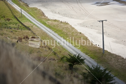 A gravel country road next to beach on the east coast, New Zealand