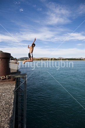 A boy jumping off Tolaga bay wharf, New Zealand