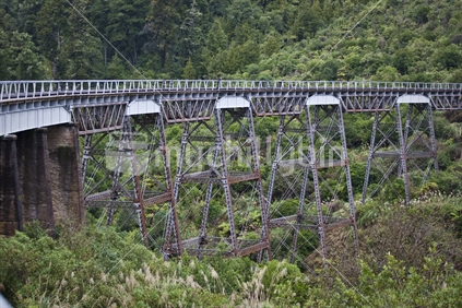 A person walking across old railway sleepers on the Hapuawhenua Viaduct, Ohakune, New Zealand