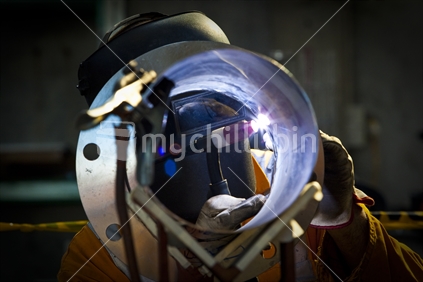 A welder working on a project in a workshop