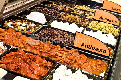 Fresh antipasto display in a food cabinet.