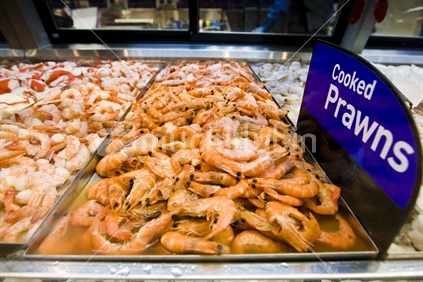 Cooked prawns on display in a refrigerated cabinet.