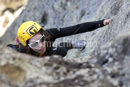 A woman arriving at the top of a rock face at Wharepapa, Waikato, New Zealand