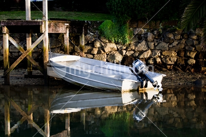 A dinghy tied to a jetty in calm water at Whitianga, Coromandel, New Zealand.