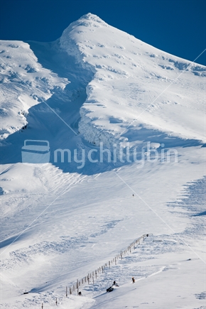Snowboarders riding down a snow covered Manganui skifield, Mt Taranaki / Egmont.