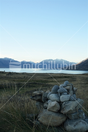 Sunset over Lake Ohau with a rock cairn in the foreground