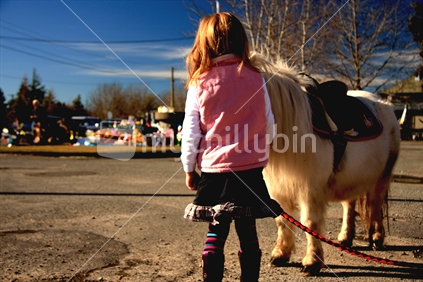 Girl patting miniature horse