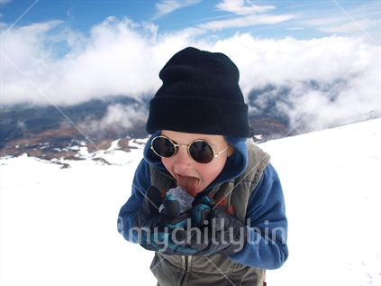 Boy licking a chunk of ice