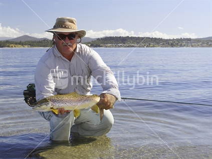 Fly fishing on the shores of Lake Brunner, West Coast, South Island (catch and release)