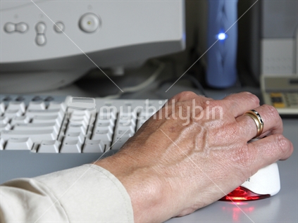 Hand on the mouse at the computer