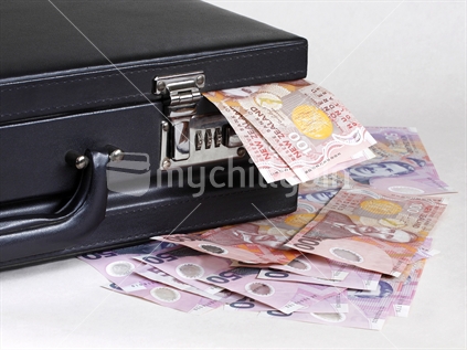 Concept for business success. Briefcase overflowing with money.
