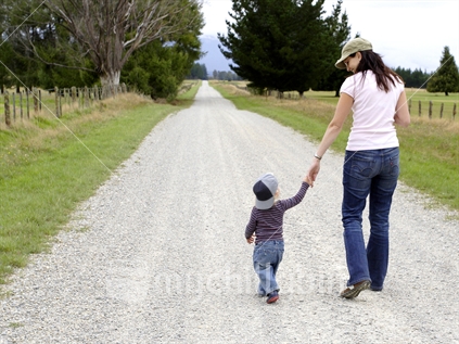 Mother and son, walking and talking along a gravel country road
