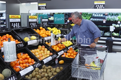 Supermarket shopping in the fruit and vege department.