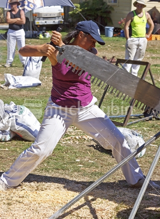 Maori female competitor in the women's single handed wood sawing competition at the woodchopping events, New Zealand.