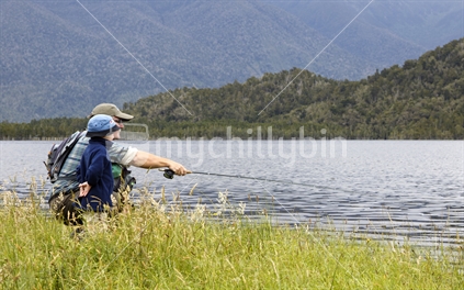 Man and boy flyfishing. West Coast, South Island, New Zealand.  