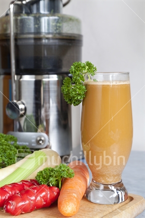Juicing raw fresh vegetables for good health.
Glass of parsnip,carrot,yam,celery and parsley juice.