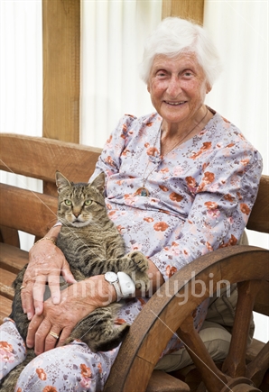 Elderly woman sitting holding her cat.