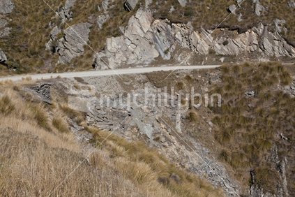 Gravel road through Danseys Pass. A mountain pass located in the Kakanui Mountains between Central Otago and North Otago, South Island, New Zealand.  Old bridge piles made from stone can be seen below the road where there has been a slip.