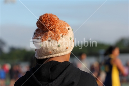 Spectator at a sports match wearing a woolly hat