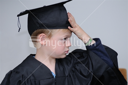 New Zealand Boy in a Gown and Mortar Board, at a Pre School Graduation.