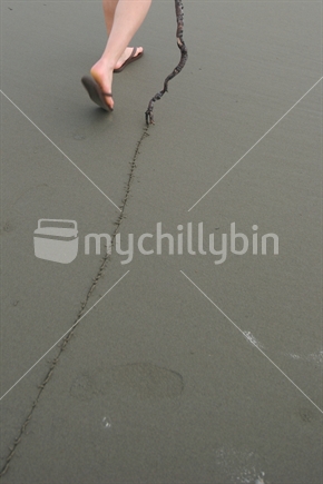 A line being made in the sand by a stick