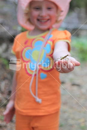 Young girl holding a stick insect