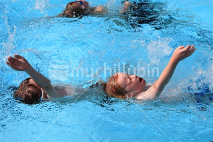 Two young boys in a swimming race
