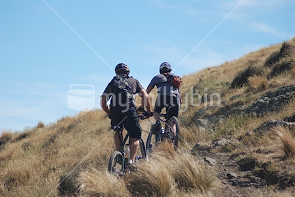 Two mountain bikers enjoying a weekend ride on the Port hills Canterbury, New Zealand
