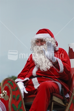 Santa waving to the crowd as he passes by