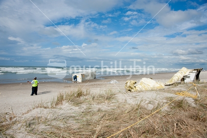 Officers provide security on Mount Maunganui ocean beach keeping public away from beached containers from the wrecked ship the Rena, on October 13 2011.