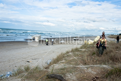 Rena ship wreck disaster. People on beach at Mount maunganui view the dbris washed up.