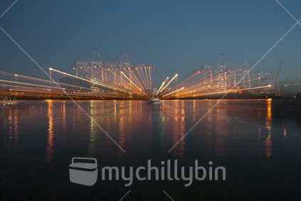 Light streams effect from port container cranes in action.