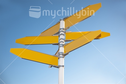 Blank signpost with five yellow arrows over blue sky - just add your text. 