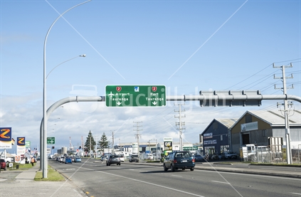 Hewletts Road Tauranga, or a part of State Highway 2 that runs through the busy industrial area showing the road, businesses and direction signe to the Port and airport. Road direction signs, May 2014.