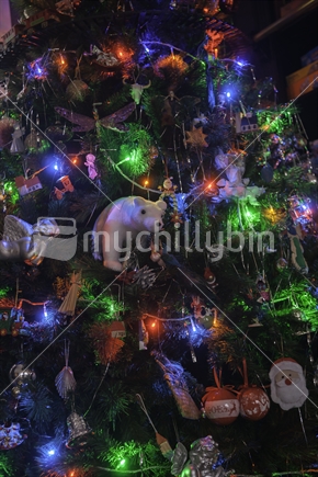 Christmas tree decorated with lights and colorful baubles and replicas.